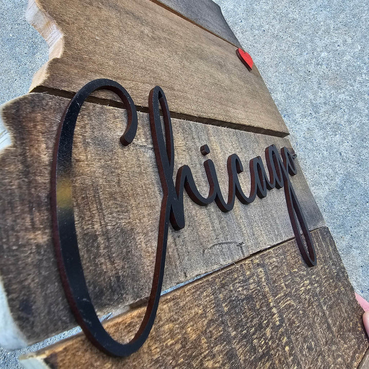 Close up of wooden sign with 'Chicago' in black lettering on a textured background