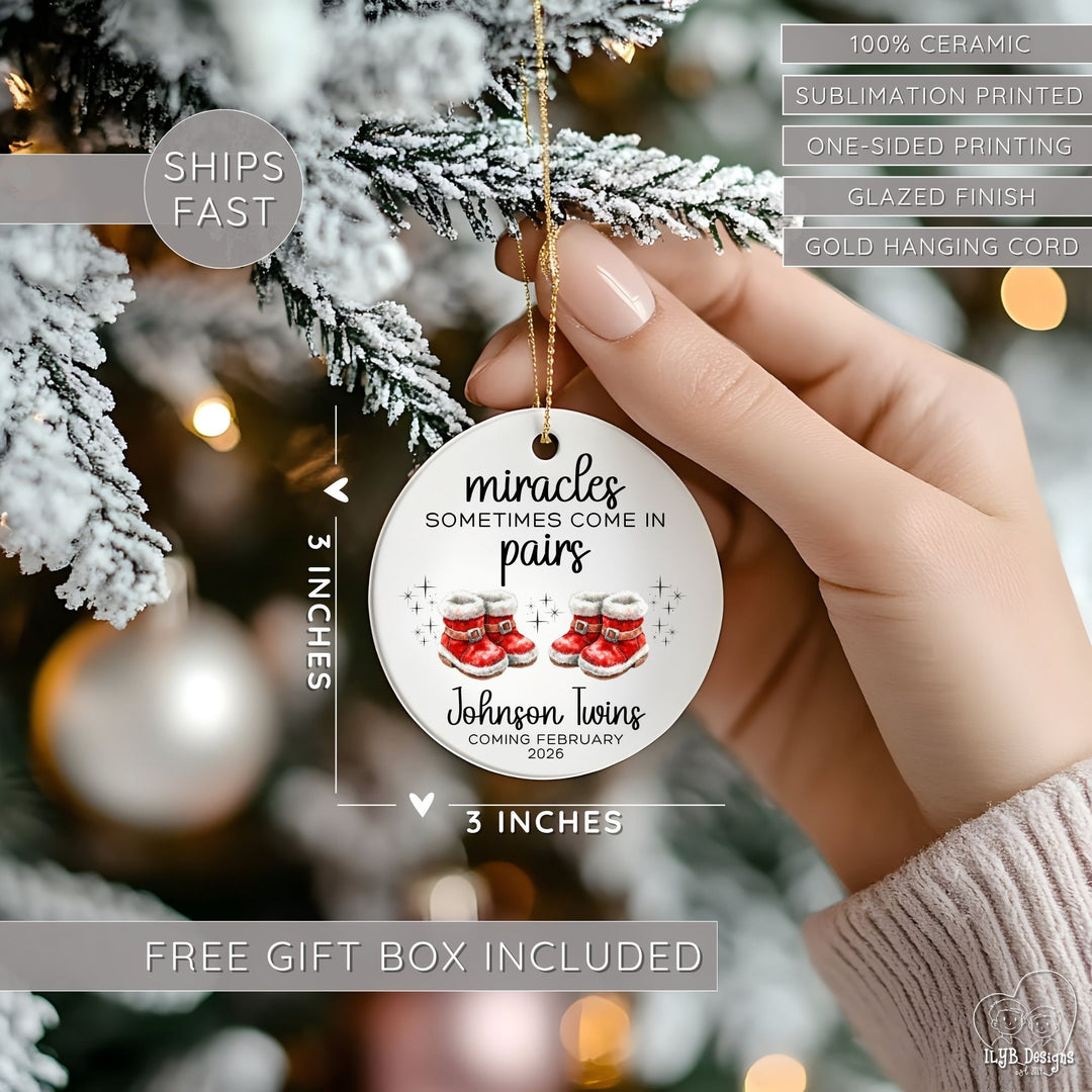 Hand hanging "miracles sometimes come in pairs" ornament on a Christmas tree and showing dimensions of the ornament in perspective next to the hand. Ornament dimensions are 3 inches x 3 inches. Other features are highlighted: 100% ceramic, sublimation printing, one-sided print, glazed finish, gold hanging cord, free gift box included, ships fast.