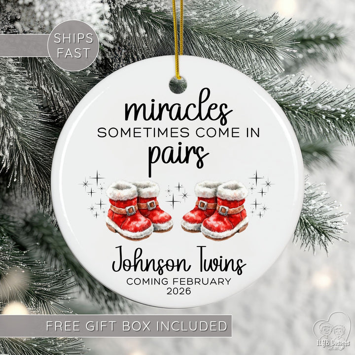Christmas ornament with red Santa boots and text 'miracles sometimes come in pairs' on a tree.