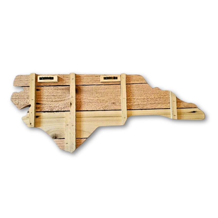Back of wooden pallet sign shaped like the state of North Carolina on a white background