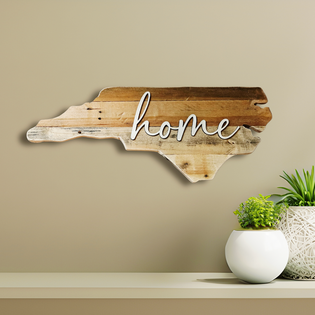 Wooden wall decor shaped like a state with 'home' text, mounted on a beige wall.