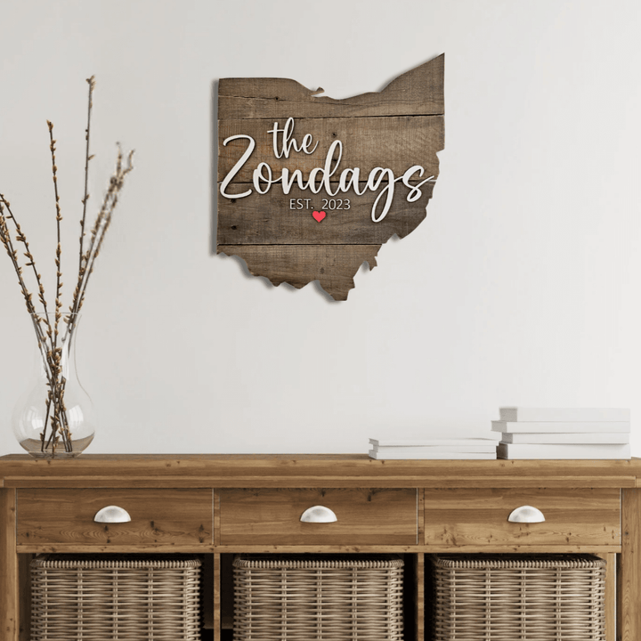 Wooden pallet wall art shaped like the state of Ohio with 'the Zondags' and 'EST. 2023' text above a wooden console table.