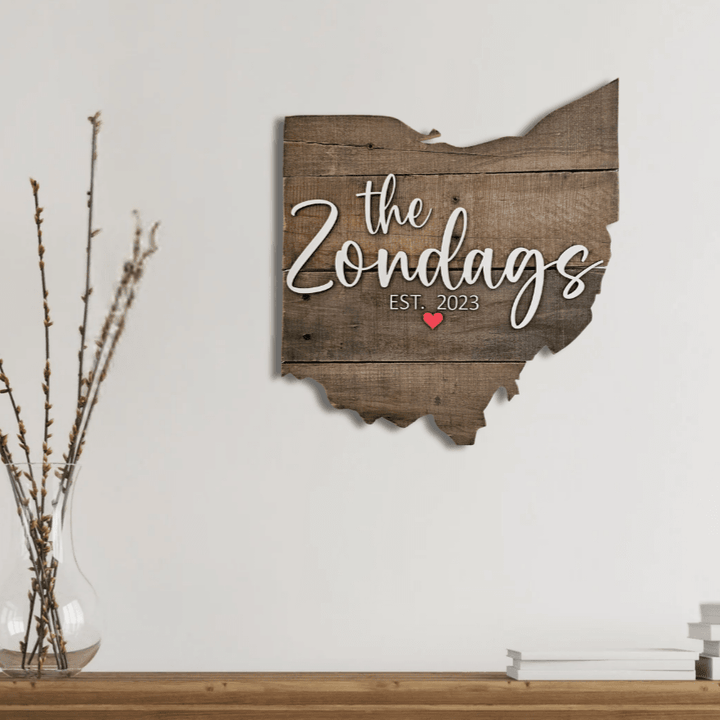 Wooden Ohio-shaped pallet wood sign with 'the Zondags EST. 2023' text on a white wall.