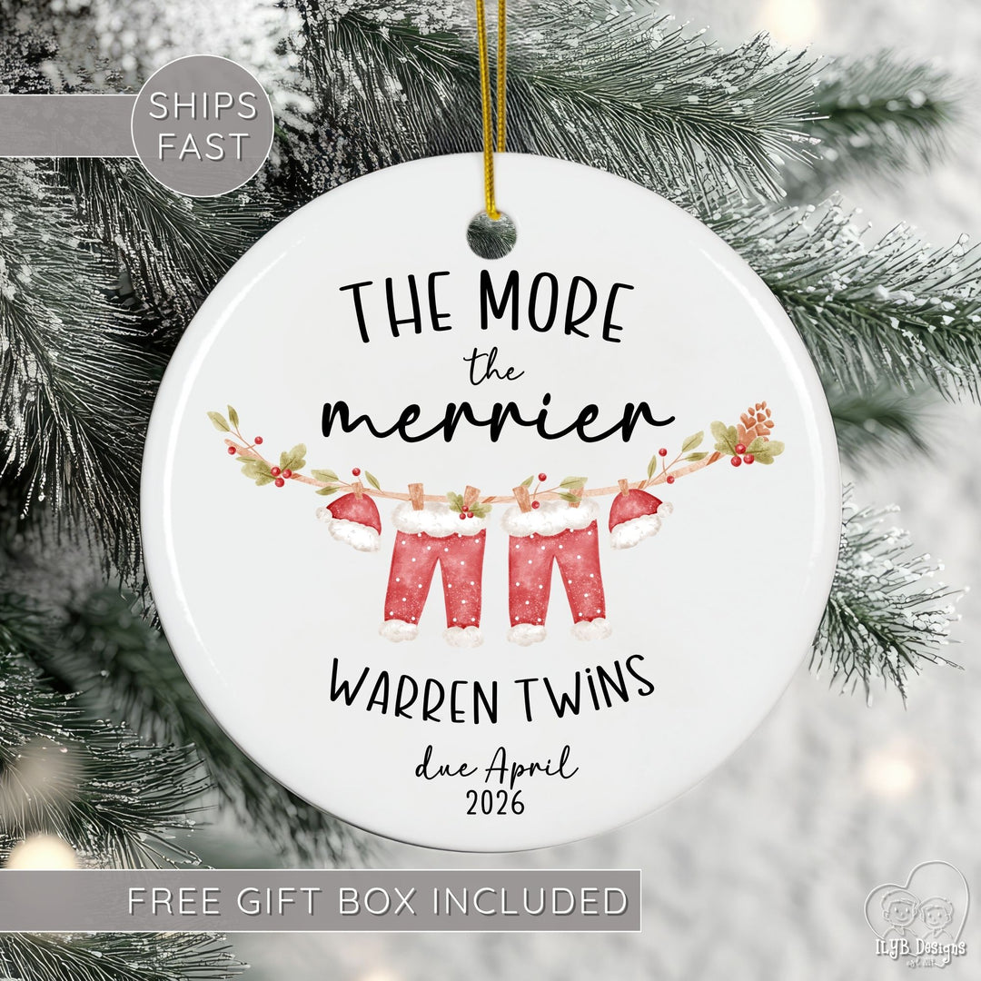 Personalized ceramic Christmas ornament for mom of multiples pregnancy featuring the festive phrase āThe More the Merrierā, your custom name, number of babies (twins, triplets, quadruplets, or more), and month/year due date. Designed with modern black script and print lettering and a cute watercolor clothesline with Santa clothes hanging for each baby, this pregnancy announcement ornament is perfect for twin pregnancy reveals, triplet announcements, or any multiples baby announcement.