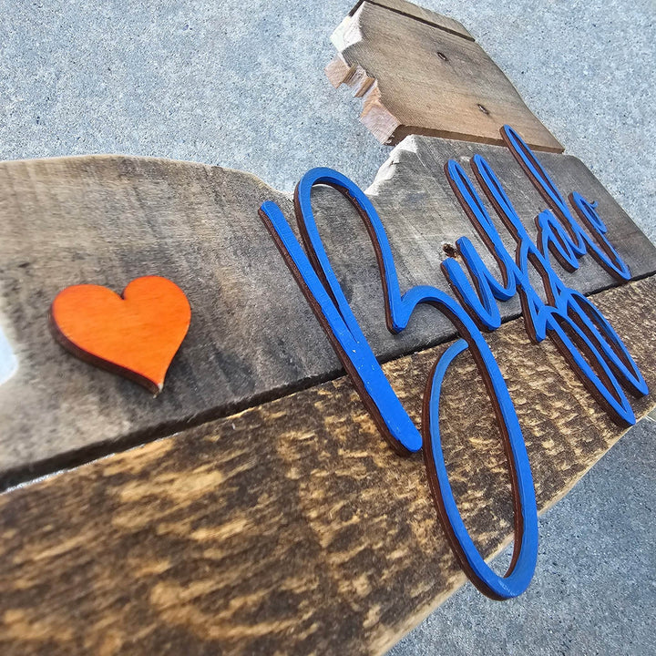Close up wooden pallet sign with blue cursive 3D text 'Buffalo' and orange heart on a concrete surface