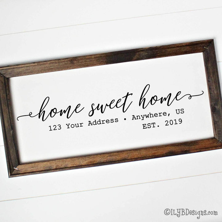 Personalized 'home sweet home' sign with wooden frame on a white canvas. A custom address and established date is underneath the phrase.