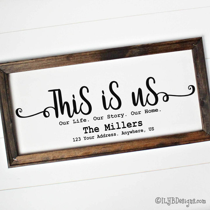 Decorative canvas sign with brown wood frame and black text 'This is us. our life. our story. our home.' text along with a family name and address.