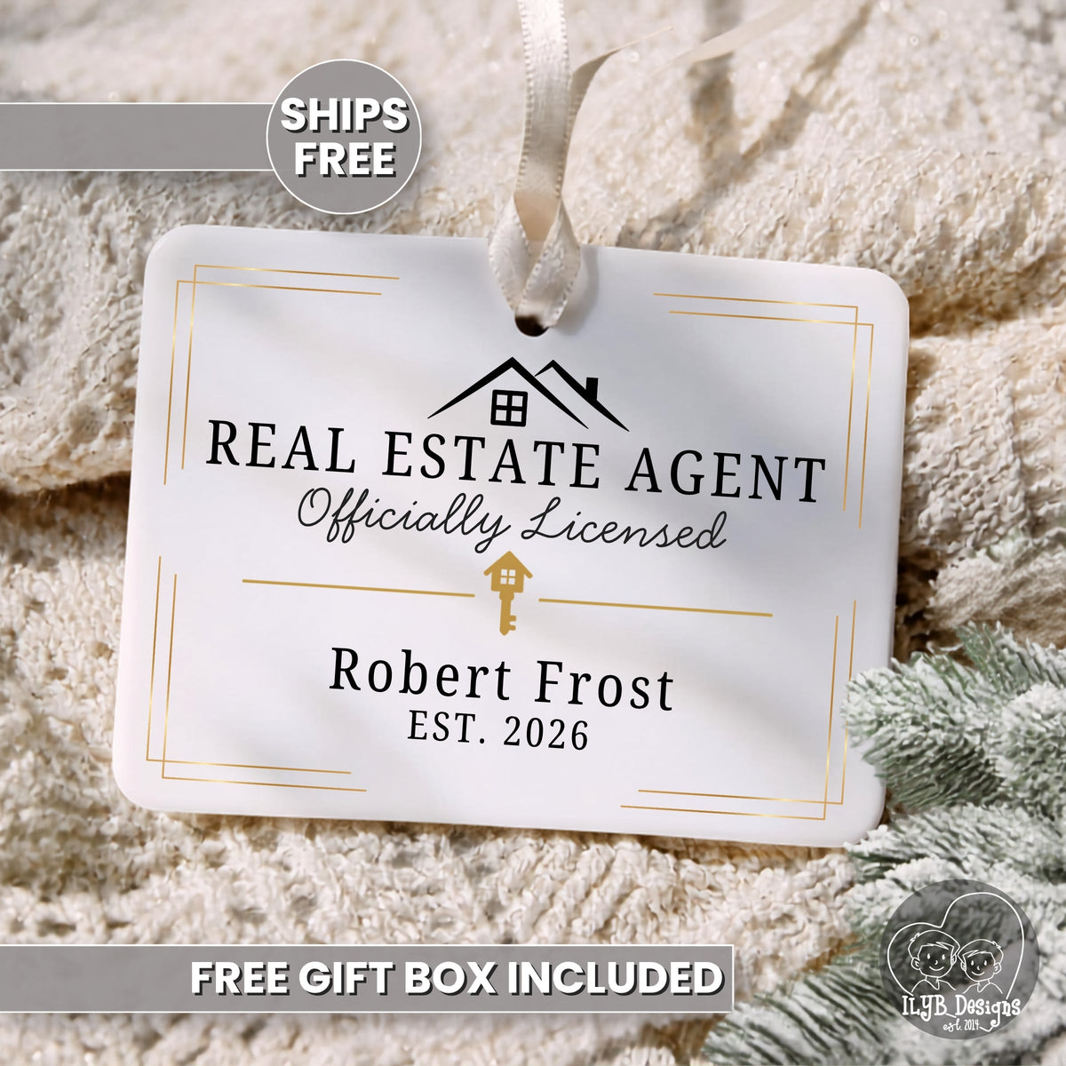 A personalized white hanging ornament with a ribbon loop, printed with 'REAL ESTATE AGENT Officially Licensed', 'Robert Frost', and 'EST. 2026', styled on a beige knit blanket with a 'SHIPS FREE' badge and 'FREE GIFT BOX INCLUDED' text.