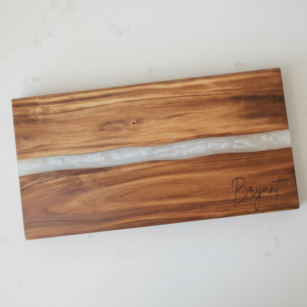Wooden cutting board with a white resin inlay and the last name 'Bryant' engraved in the bottom right corner.