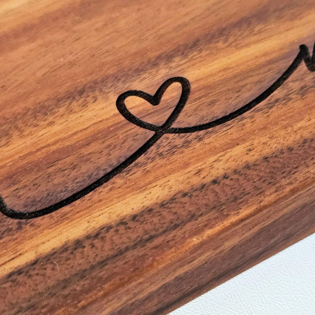 Close-up of wooden charcuterie board with a heart-shaped engraving in the wood