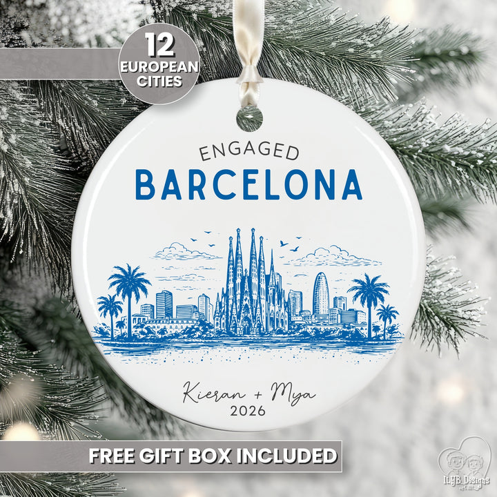 A round white ceramic Christmas ornament featuring a blue illustrated Barcelona skyline with the text &