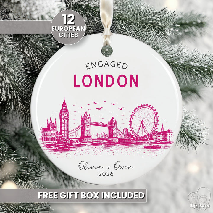 A round white ceramic Christmas ornament featuring a pink illustrated London skyline with the text &