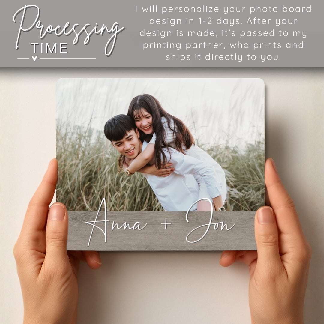 Person holding a photo board with a printed image of two people and personalized names 'Anna + Jon'.