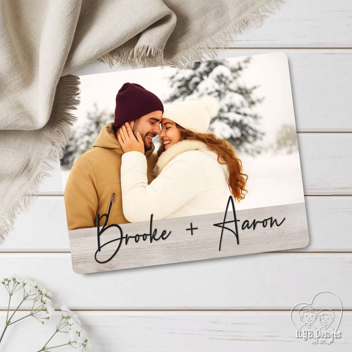 Personalized photo plaque with a couple in winter clothing and 'Brooke + Aaron' text, on a wooden surface.