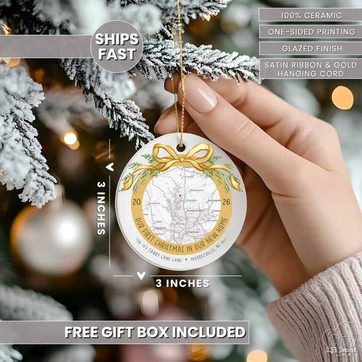 A hand holds a round ceramic Christmas ornament with a map and address with the words &