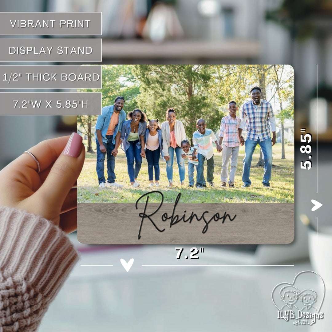 Wooden photo print with family photo and 'Robinson' engraving, held by a hand.
