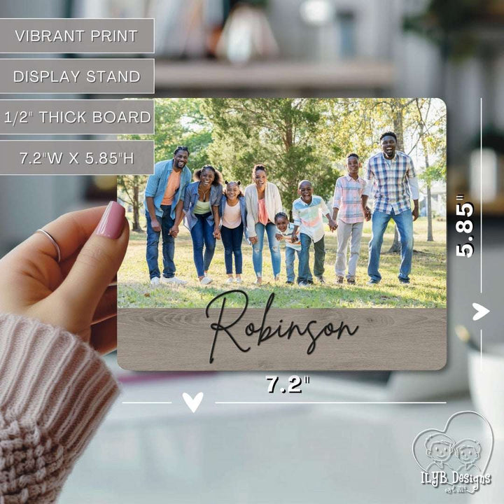 Wooden photo print with family photo and 'Robinson' engraving, held by a hand.