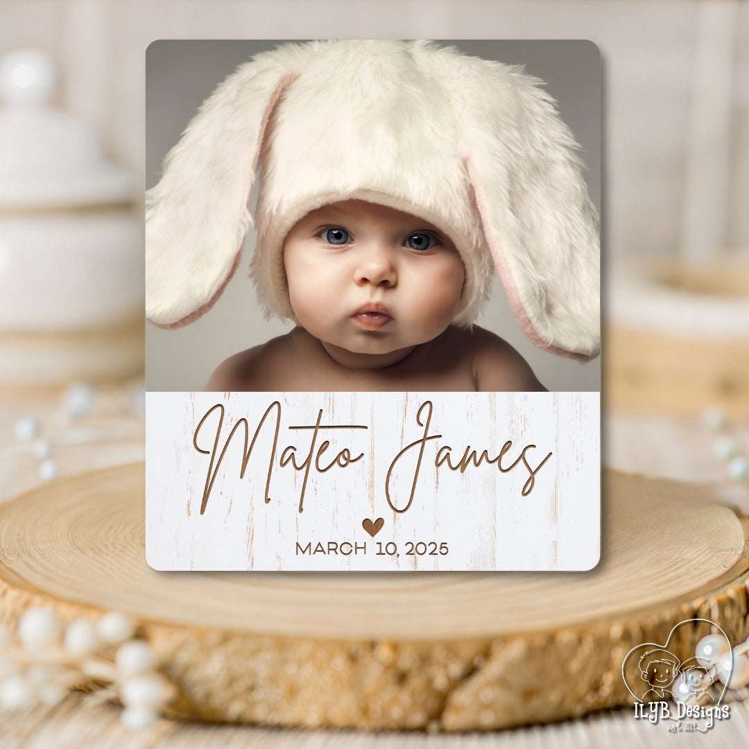 Baby wearing a bunny hat with a nameplate on a wooden surface
