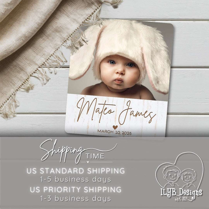 Baby wearing a bunny hat with personalized name card on a wooden surface