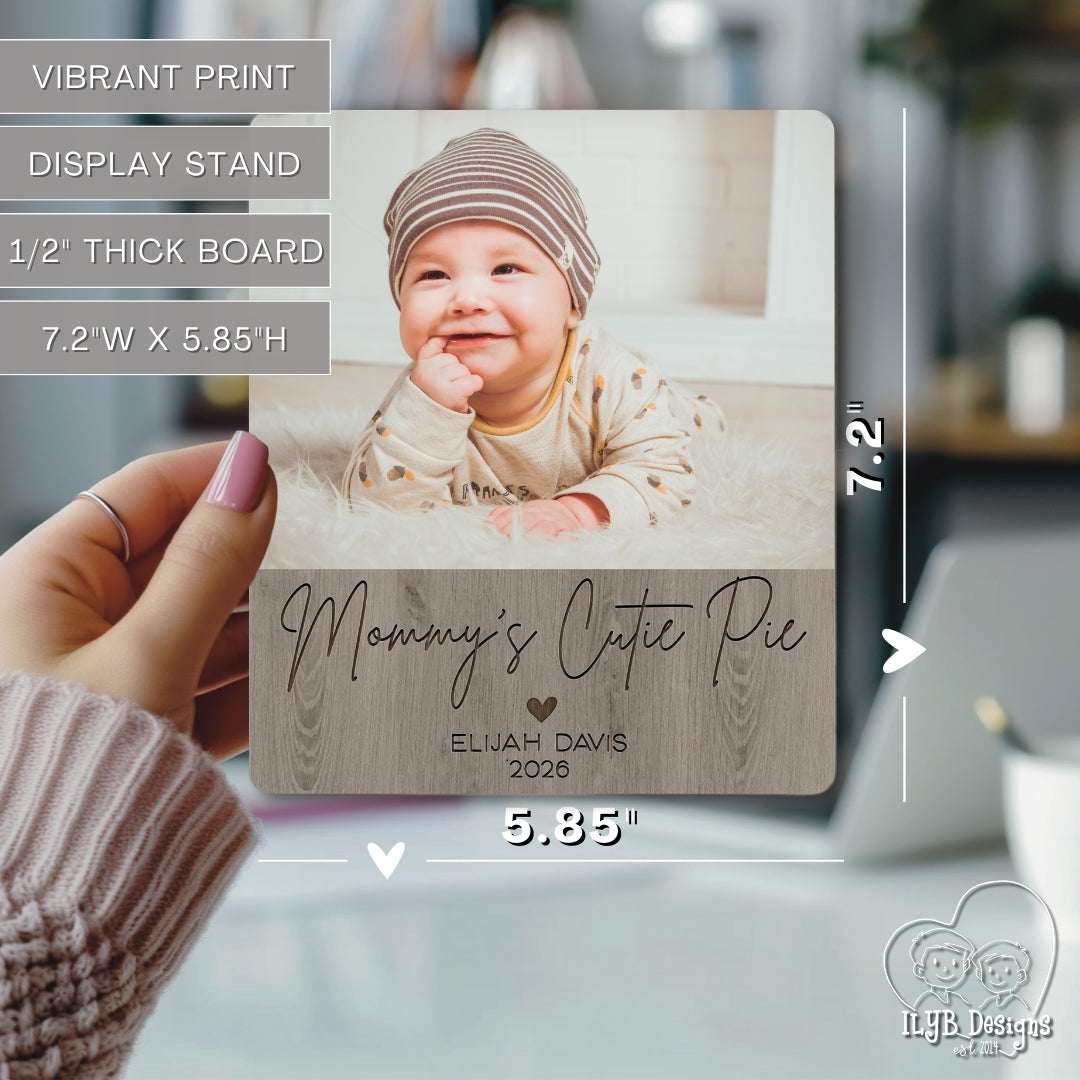 Wooden photo plaque with a baby's photo and text, held by a hand.