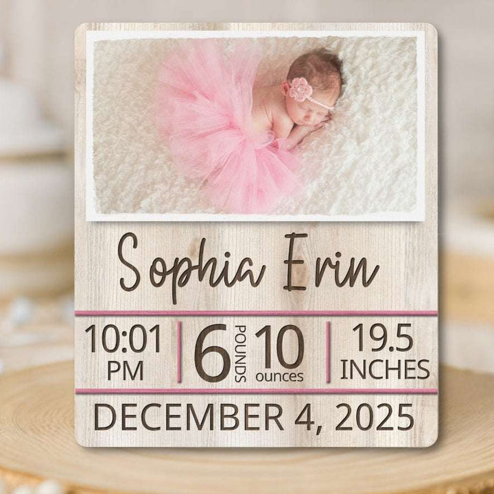 Wooden plaque with baby photo and birth details on a wooden surface