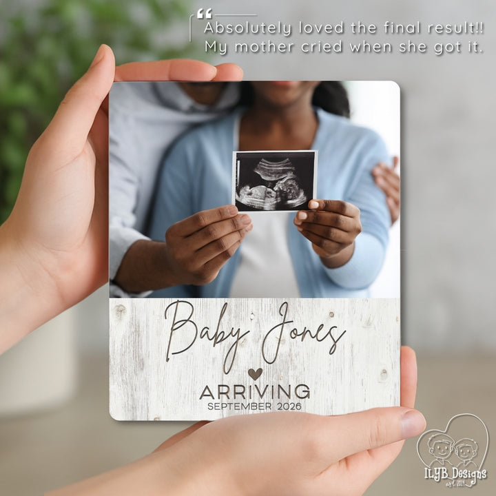 Person holding a photo plaque with an ultrasound photo and 'Baby Jones Arriving' text.