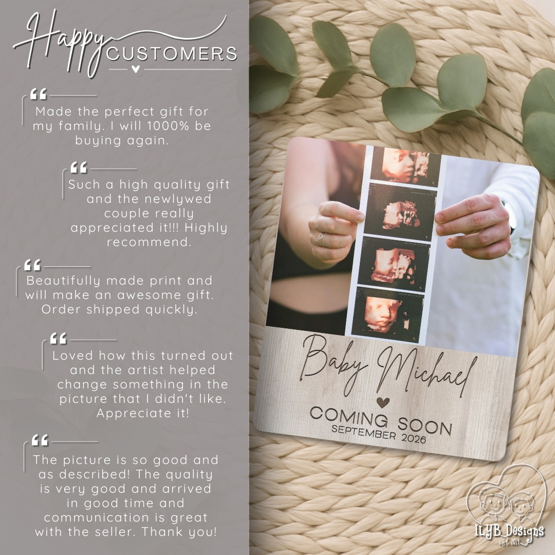 Wooden baby announcement plaque with photos and text on a textured surface with leaves.