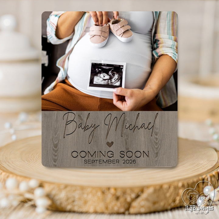 Pregnant belly with baby shoes and ultrasound photo, 'Baby Michael Coming Soon September 2023' text on a wooden surface.