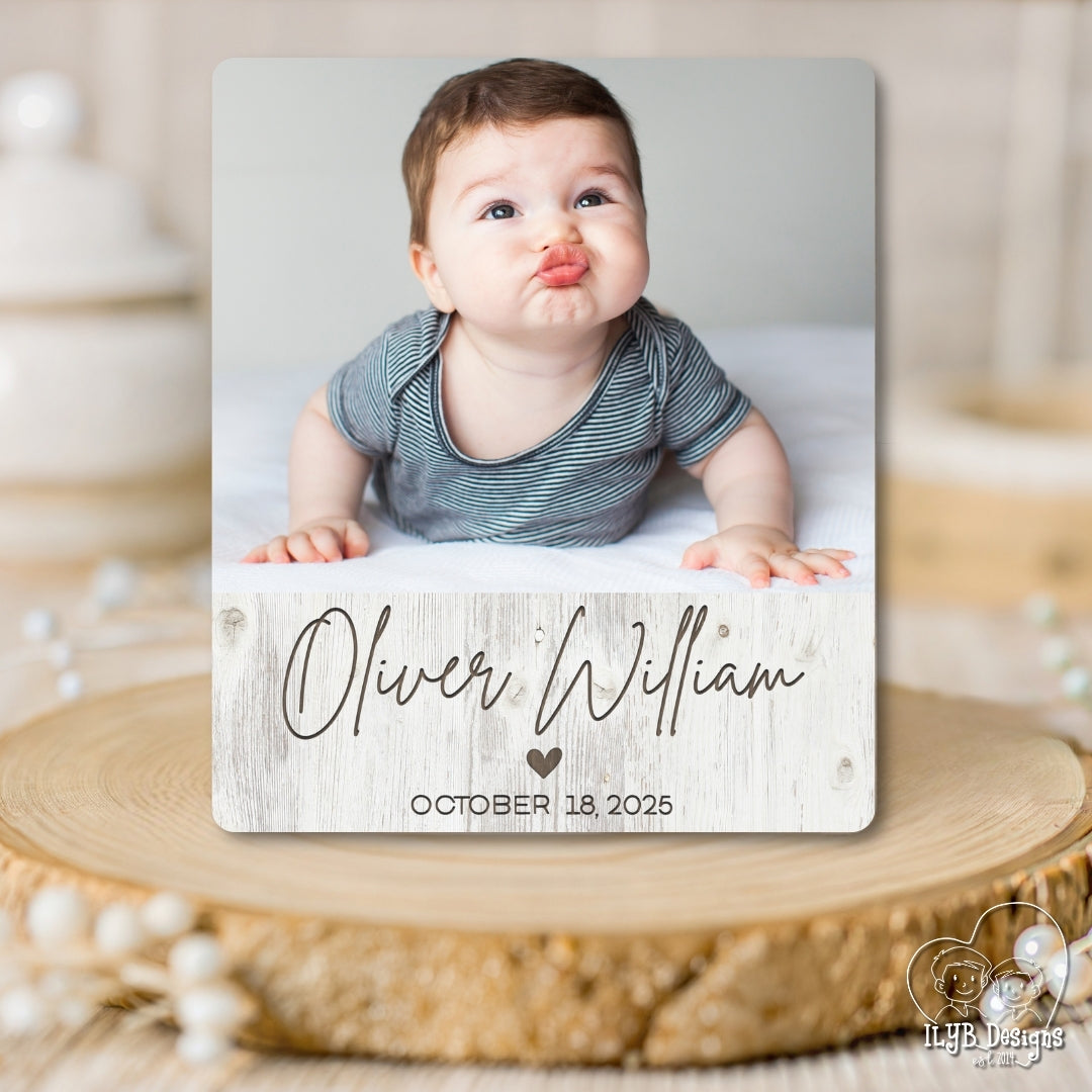 Baby photo with name and date on a wooden surface