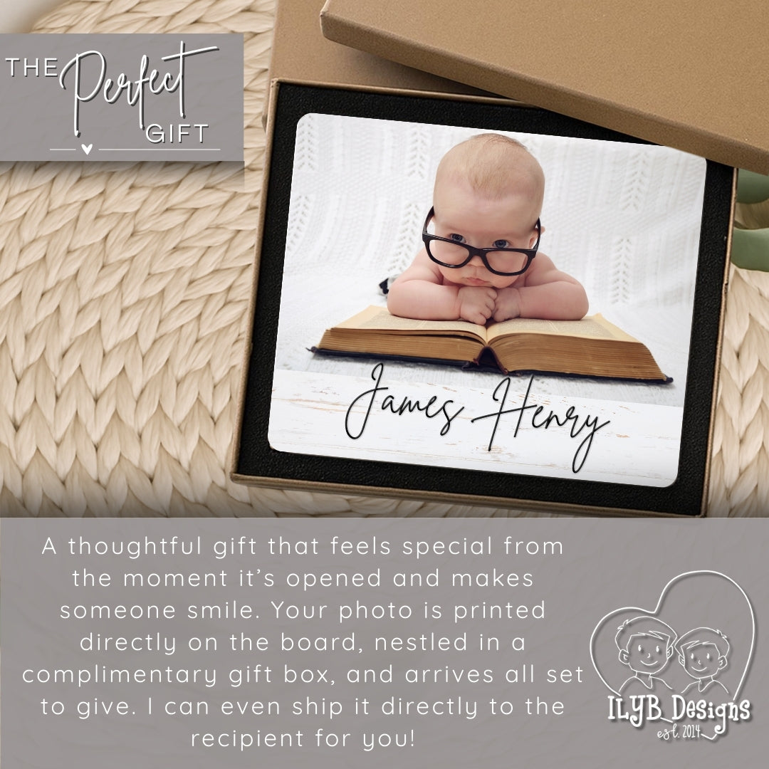 Personalized photo gift with a baby wearing glasses on an open book, in a decorative box.