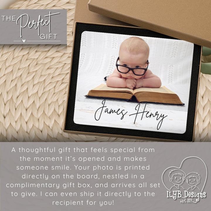 Personalized photo gift with a baby wearing glasses on an open book, in a decorative box.