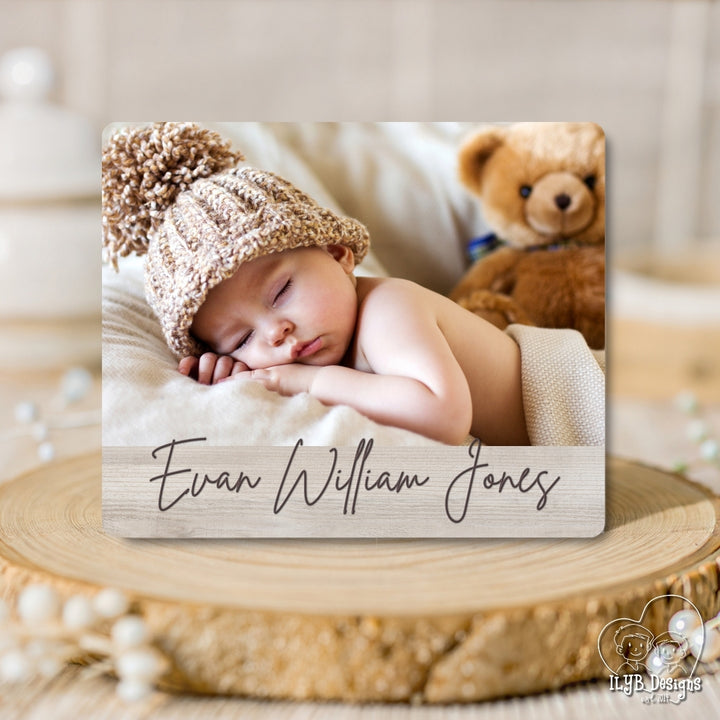 Baby sleeping with a knitted hat and teddy bear, name engraved on wooden plaque