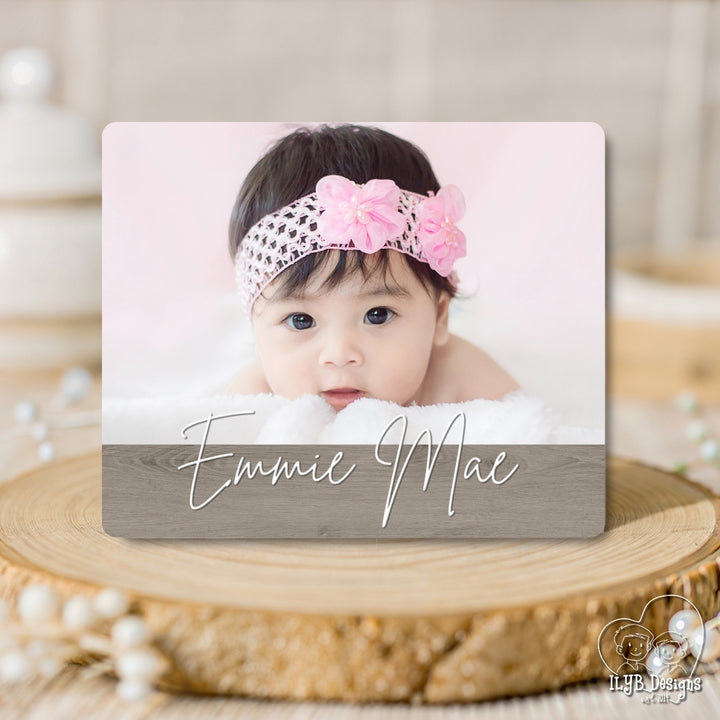 Baby photo board with 'Emmie Mae' on a wooden surface