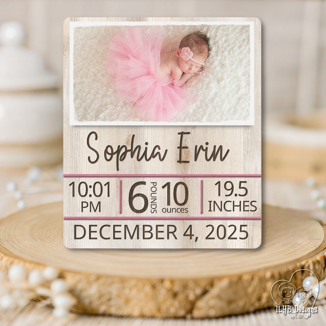 Wooden plaque with baby photo and birth details on a wooden surface