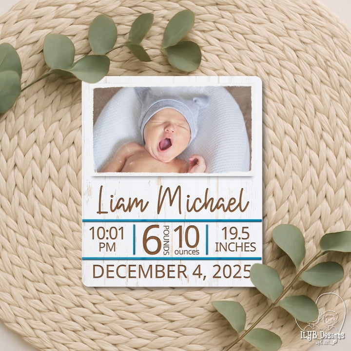 Baby photo with birth details on a textured surface with green leaves