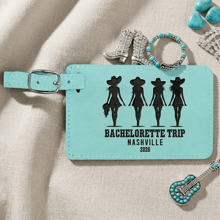 Turquoise luggage tag with 'Bachelorette Trip Nashville 2026' text and silhouette design on a beige fabric background.