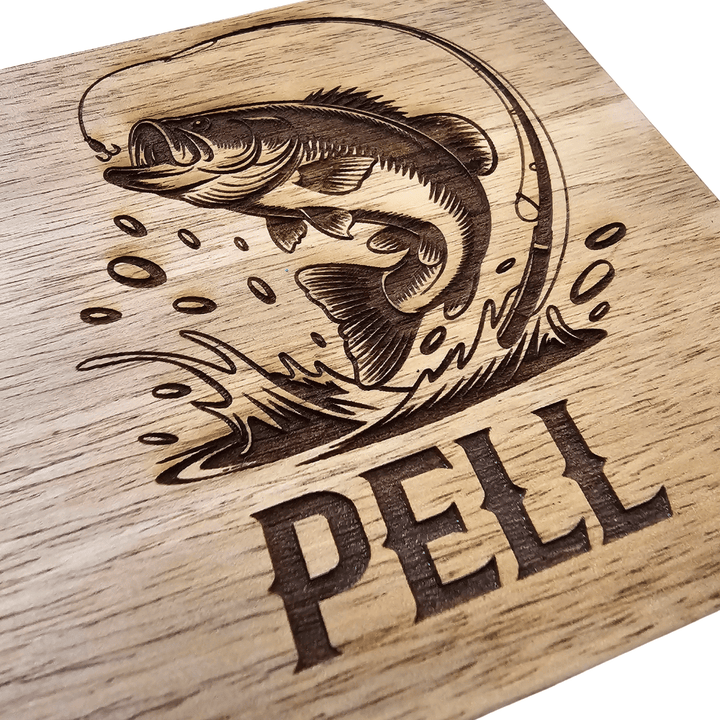 Close up of Wooden cutting board engraving of a fish and 'PELL' text