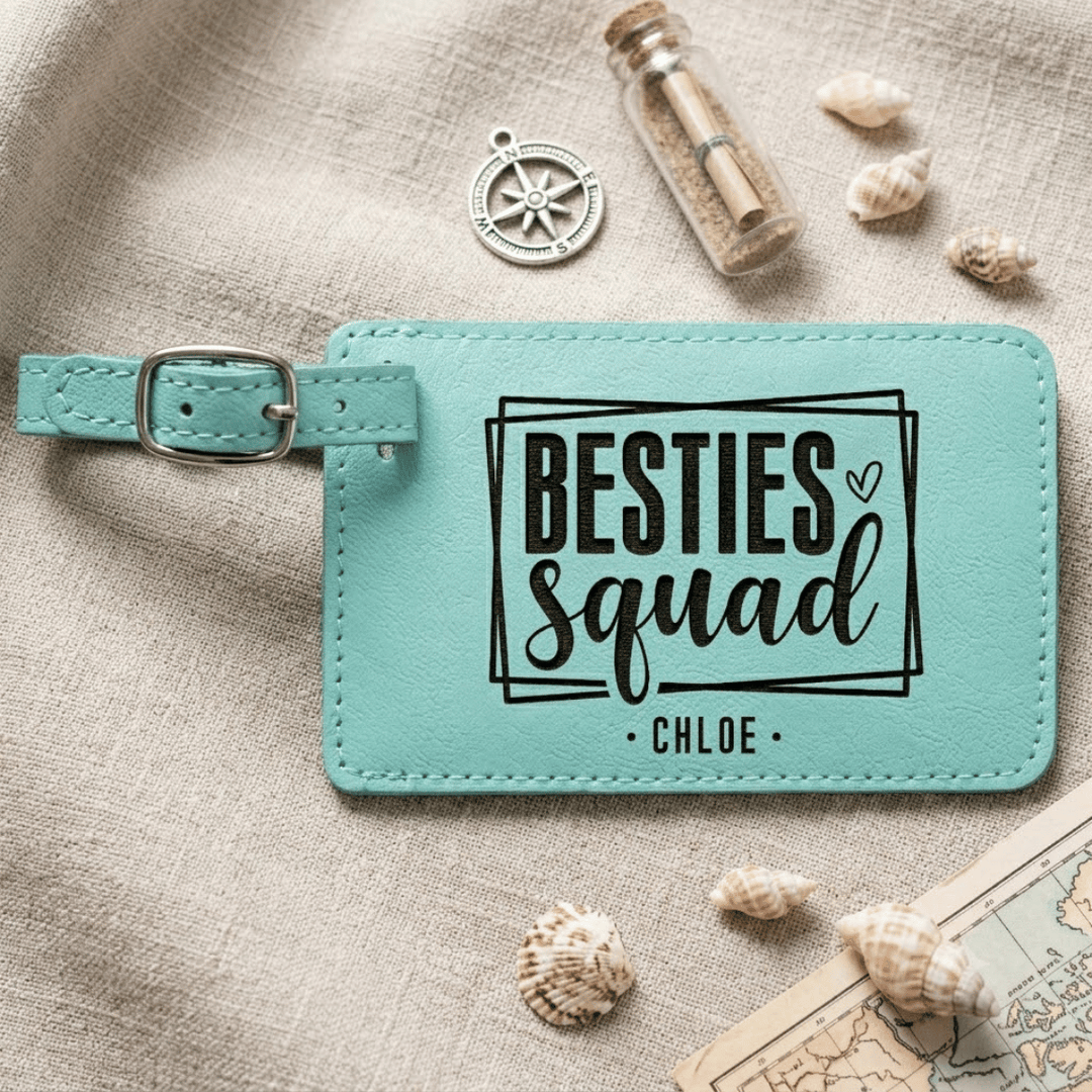 Turquoise luggage tag with 'BESTIES squad' text on a textured surface with shells and a map.