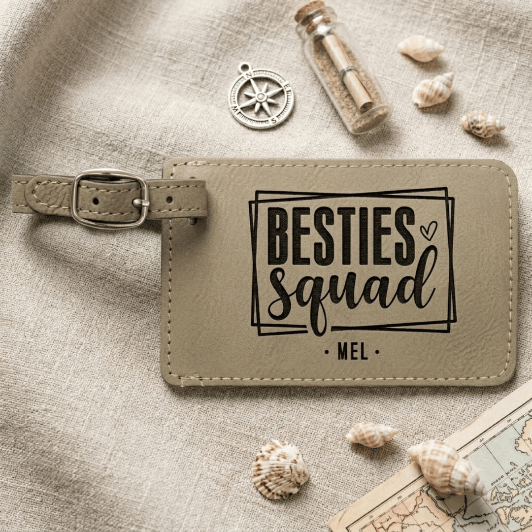 Beige luggage tag with 'BESTIES Squad' text on a textured surface with shells and a map.
