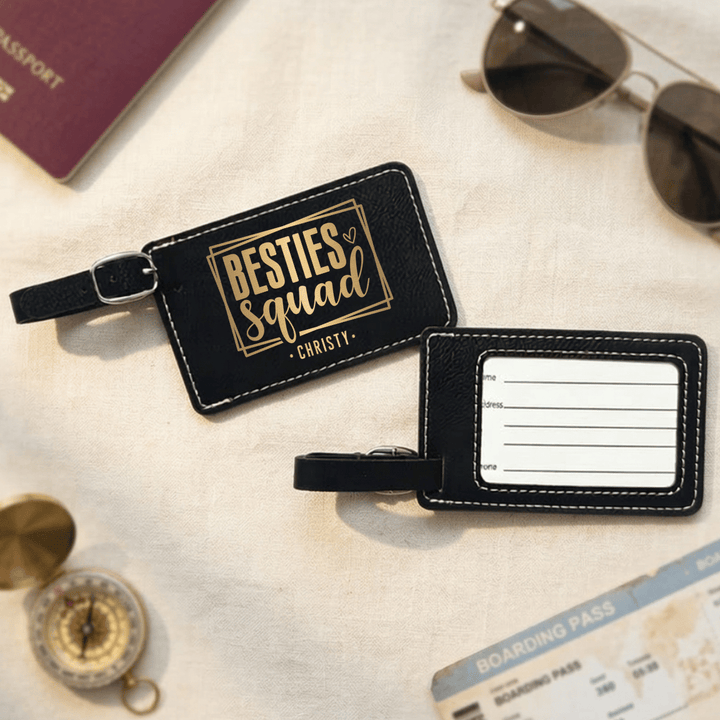 Black luggage tag with 'besties squad Annie' engraved in black on the front and the back has clear plastic opening with space to write personal information.