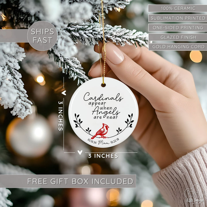 Hand hanging cardinal memorial ornament on a Christmas tree and showing dimensions of the Christmas ornament in perspective next to the hand. Ornament dimensions are 3 inches x 3 inches. Other features are highlighted: 100% ceramic, sublimation printing, one-sided print, glazed finish, gold hanging cord, free gift box included, ships fast.