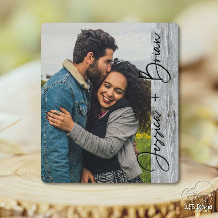 Personalized photo board with a couple's photo and names on a wooden surface.