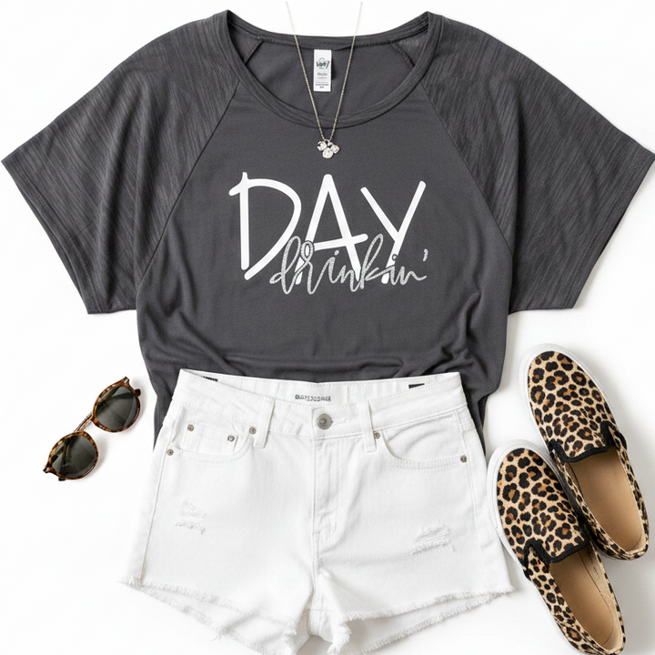 A styled flat-lay outfit featuring a dark charcoal dolman t-shirt with &