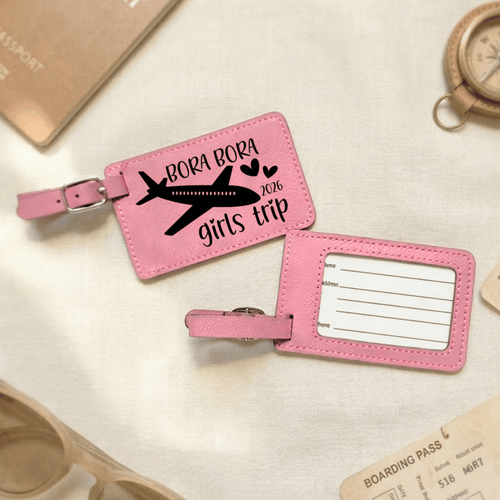Pink luggage tags with airplane design and text on a travel-themed background