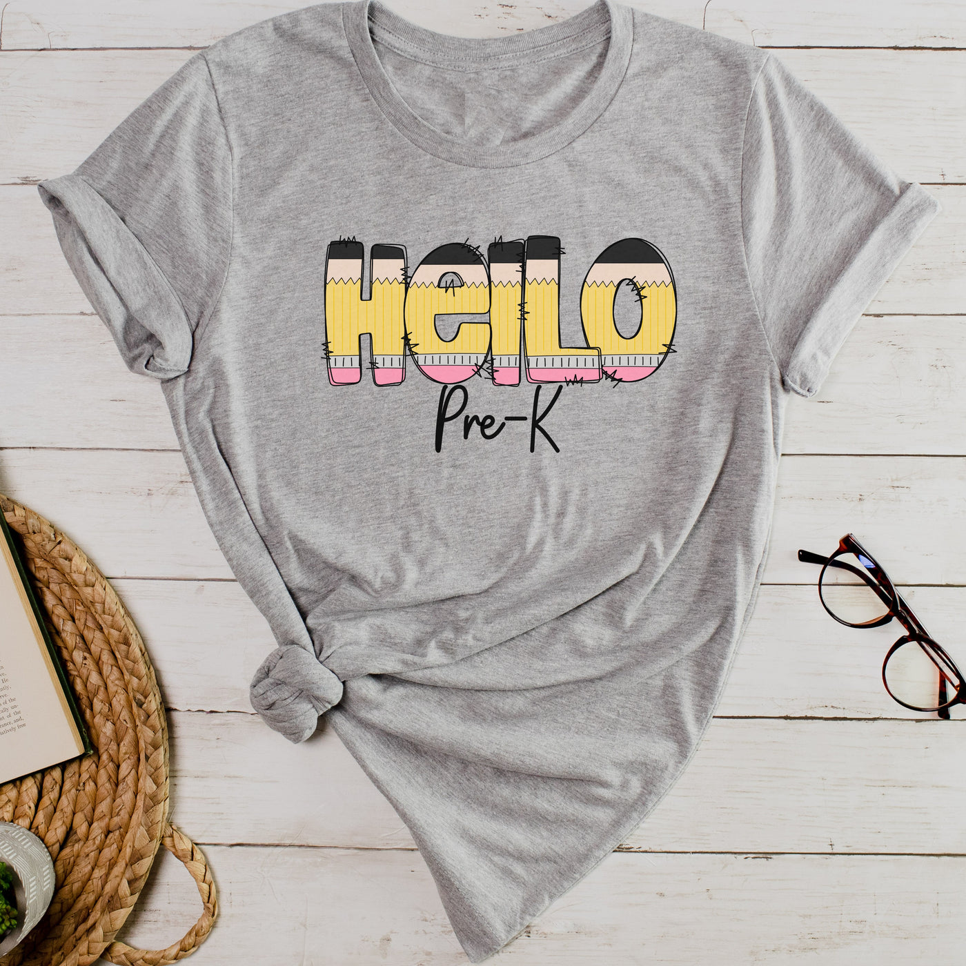 Athletic gray personalized teacher shirt with hello in pencil letters and pre k in black script underneath.