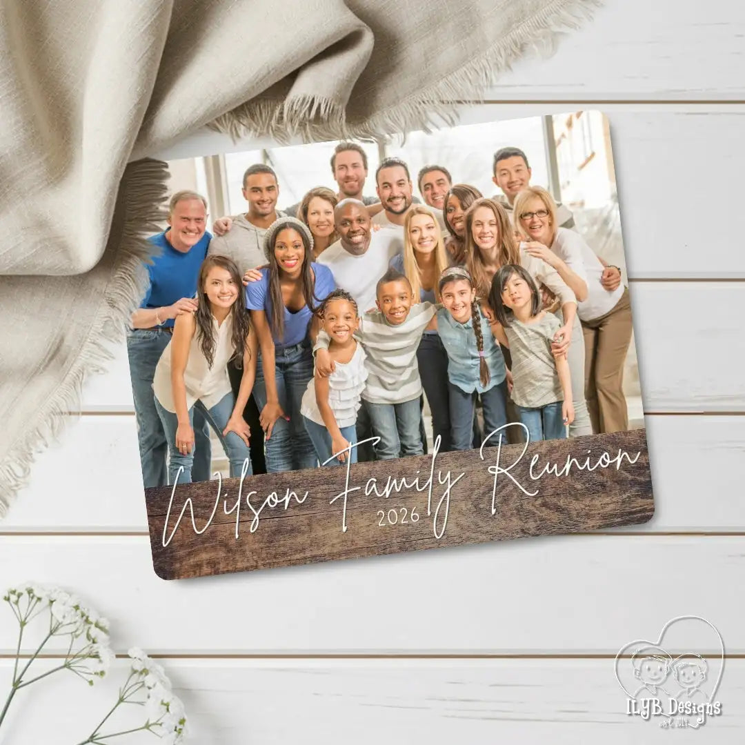 Family photo with 'Wilson Family Reunion 2026' text on a wooden board against a wooden background.