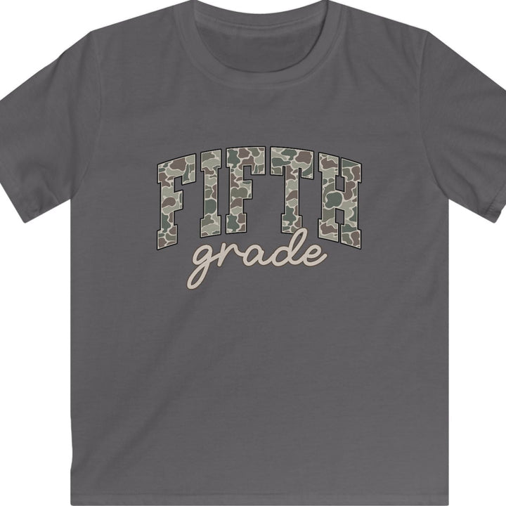 A dark gray short-sleeve t-shirt with a graphic on the chest reading 'FIFTH grade'. The letters 'FIFTH' are filled with a green and brown camouflage pattern, while 'grade' is written below in a light beige script font.