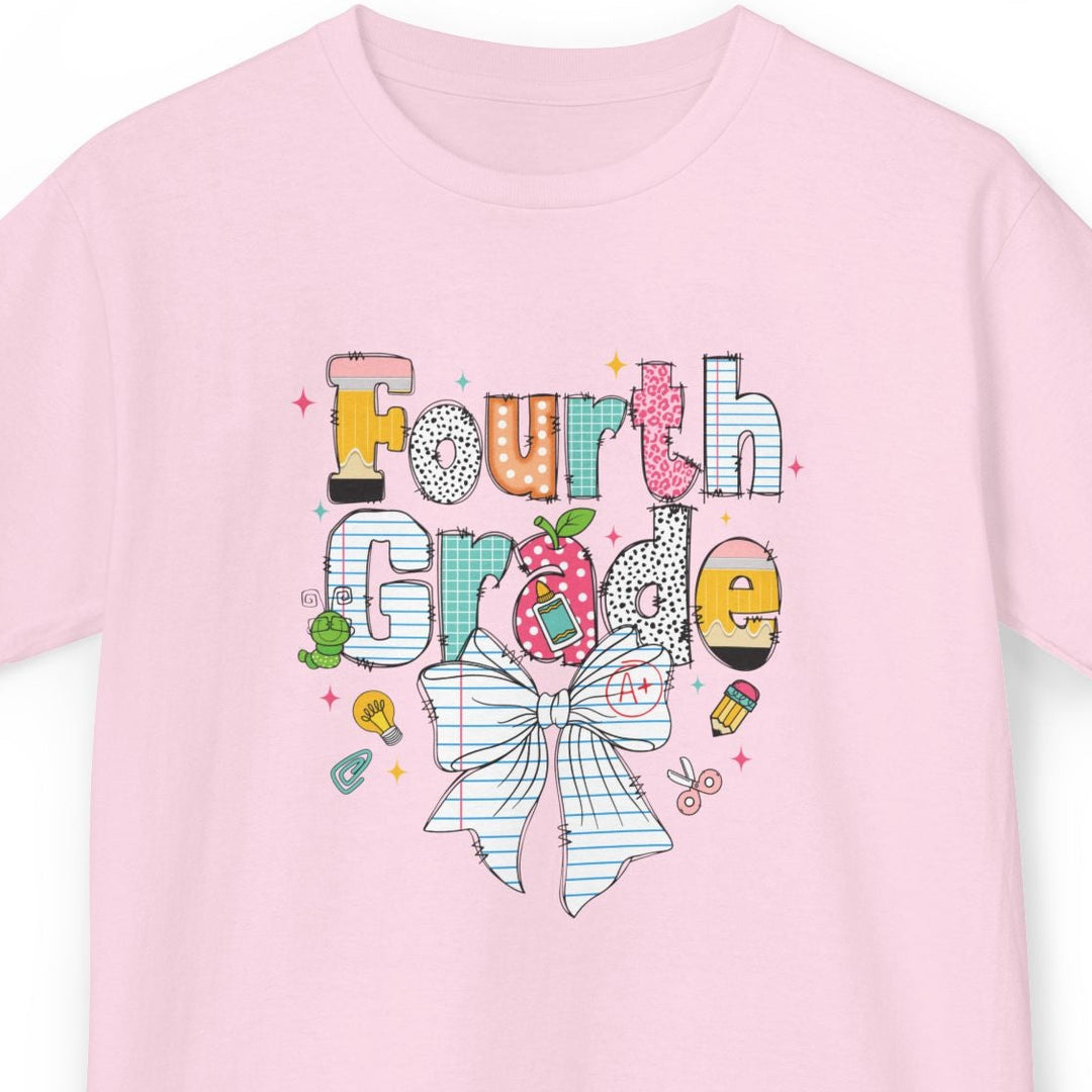 A light pink short-sleeve t-shirt with a colorful graphic on the front that reads 'Fourth Grade' in playful lettering with a striped bow, candy, and school accents, shown on a plain white background.