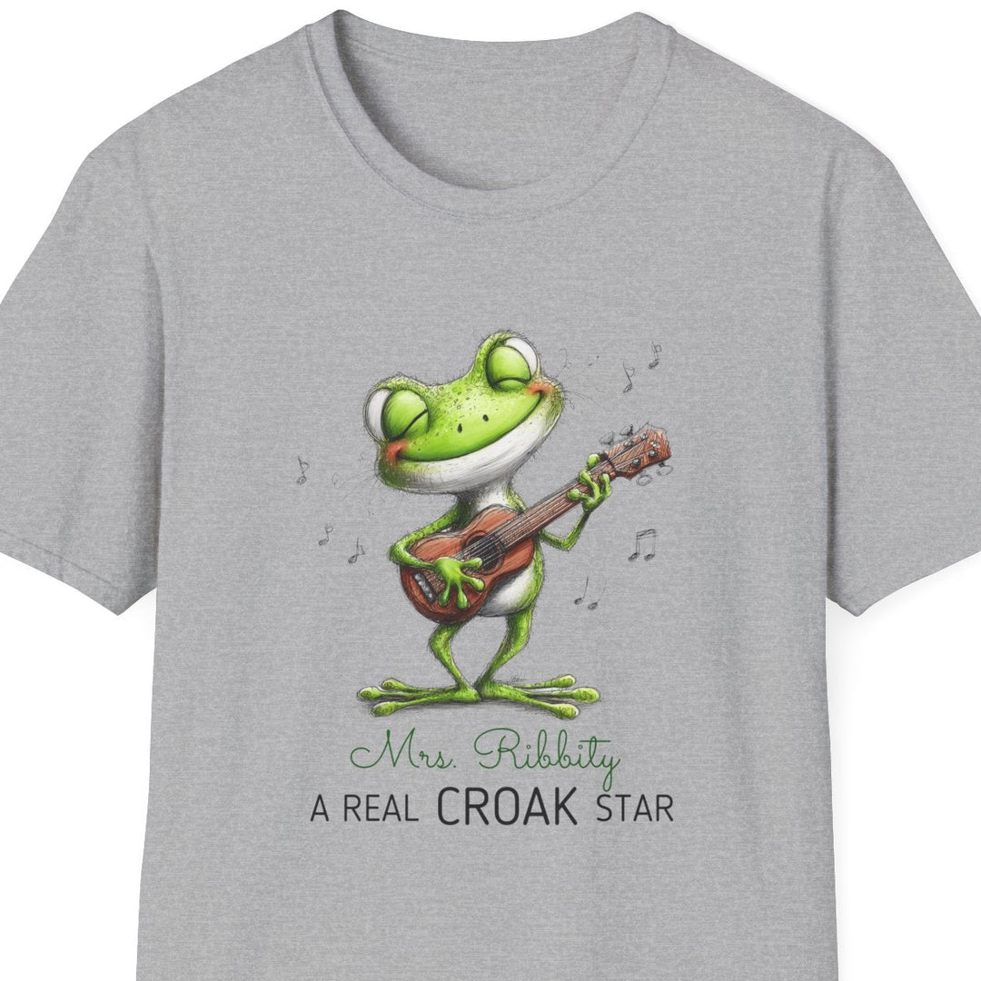 A light gray heather crewneck t-shirt featuring a cartoon frog playing a guitar with the text 'Mrs. Ribbity A REAL CROAK STAR' printed on the front.
