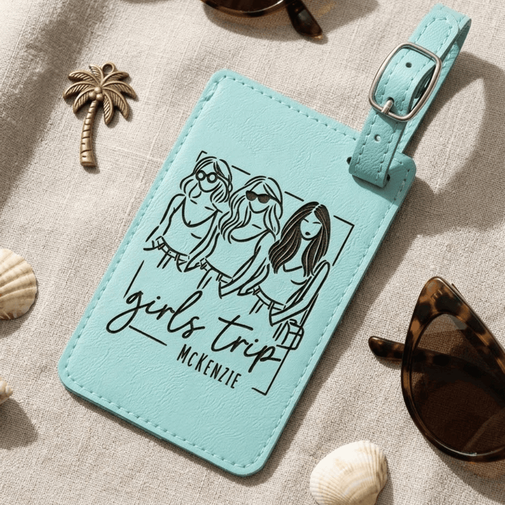 Teal luggage tag with 'girls trip' design and personalized name on a textured surface.